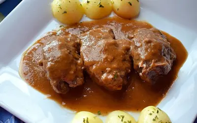 Carrilleras al vino tinto, tiernas y jugosas, bañadas en una rica salsa, acompañadas de patatas cocidas.
