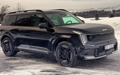 Svart Kia EV9 står på en snöig väg. Bilen har en imponerande kia ev9 vikt och ser redo för vinterväglag.