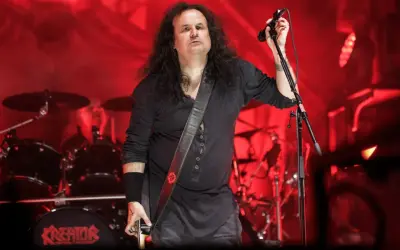 Miland "Mille" Petrozza, lider zespołu Kreator, podczas koncertu. Na bębnie widnieje logo Kreator, co podkreśla jego rolę jako kreatora albumów.