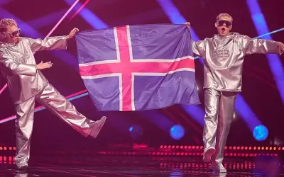 Dwóch artystów w srebrnych strojach prezentuje flagę Islandii na scenie Eurowizji.