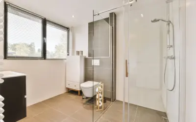 Salle de bain moderne avec douche italienne surélevée avec marche, toilettes suspendues et meuble vasque.