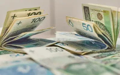 Pieniądze, banknoty 100 i 50 zł, leżące na stole. Może to być dodatek aktywizacyjny dla pracowników.