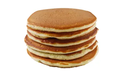 Pile de pancakes dorés faits maison avec de la farine complète, prêts à être dégustés.