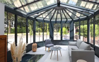 Une extension veranda moderne baignée de lumière, avec un salon confortable et une vue imprenable sur le jardin verdoyant.