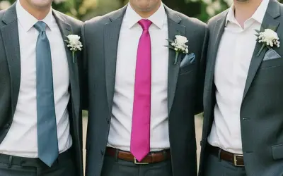 Groomsmen in grey suits with different colored ties. This image shows that you do not have to wear a tie to a wedding, but it's a stylish choice.