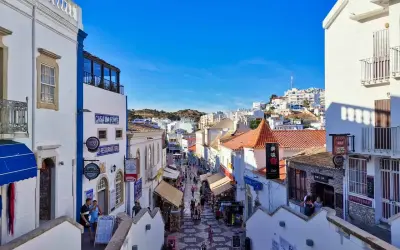 Bunte Gassen in Albufeira, Algarve, mit Geschäften und Restaurants, die sich den Hügel hinaufschlängeln.