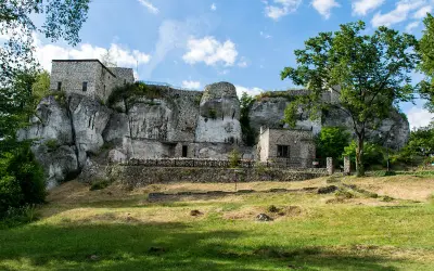 Ruiny zamku na skale, zielona trawa i drzewa. Wspaniałe morsko atrakcje dla miłośników historii i przyrody.