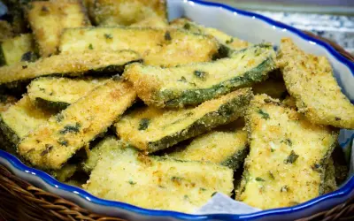 Fettine di zucchine impanate e dorate, pronte per essere gustate. Un contorno sfizioso e leggero, perfetto per ogni occasione.
