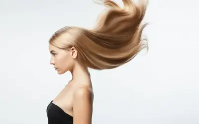 Perfil de mujer con pelo largo rubio y sedoso que se mueve con el viento.