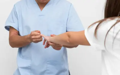 Fizjoterapeuta bada palec pacjentki. Gdy masz wybity palec, do jakiego lekarza się udać?