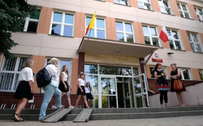 Uczniowie wchodzą do szkoły, przypominając czasy, kiedy powstały gimnazja w Polsce.