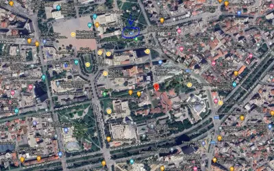 Centrum Tirany, z widocznymi **albania lotniska** w oddali. Plac Skanderbega, parki i budynki miejskie.