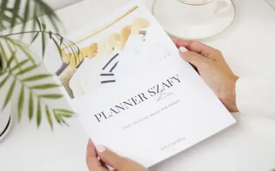 Kobieta trzyma planer szafy z wieszakami i ubraniami.