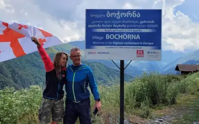 Para podróżników z flagą Gruzji w Bochorna, najwyżej położonej osadzie w Europie. Odpowiedź na pytanie: czy w Gruzji jest bezpiecznie? Tak!