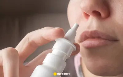 Dłoń trzymająca atomizer leku Avamys, gotowa do aplikacji do nosa.