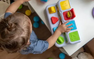 Dziecko bawi się zabawką edukacyjną. Zastanawiasz się, ile kosztuje żłobek miesięcznie?