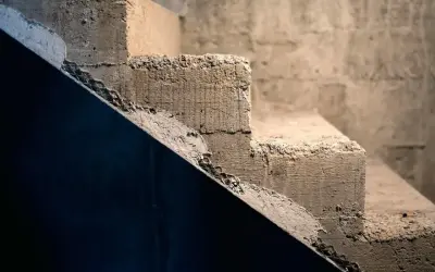 Surowe schody betonowe, idealne do rozważenia, jak tanio wykończyć schody betonowe. Tekstura betonu i siatka zbrojeniowa.