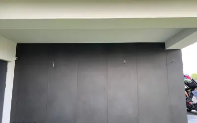 Nowoczesna elewacja z płyt spieku kwarcowego w ciemnoszarym kolorze, tworząca minimalistyczną i elegancką fasadę.
