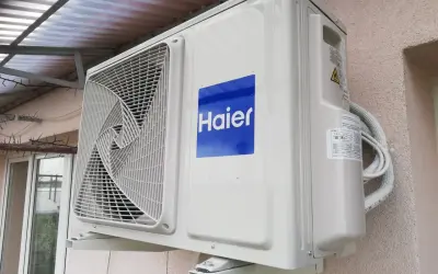 Jednostka zewnętrzna klimatyzatora Haier zamontowana na ścianie budynku.