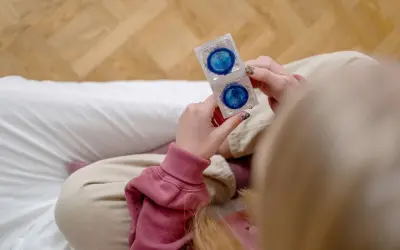 Dłonie trzymają opakowanie z dwoma prezerwatywami. To ważny element, gdy zastanawiasz się, co to antykoncepcja.