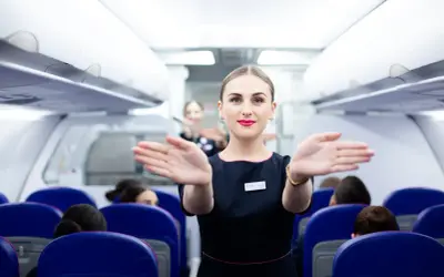 Uśmiechnięta stewardessa Wizzair wita pasażerów. Czy trzeba drukować kartę pokładową Wizzair? Sprawdź przed podróżą!