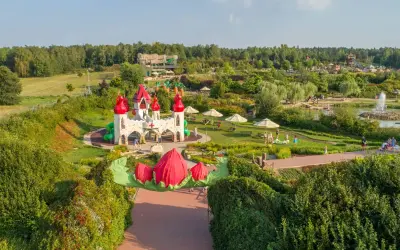 Bajkowy zamek i plac zabaw, gdzie są magiczne ogrody. Dzieci bawią się wśród zieleni i kolorowych kwiatów.