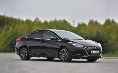 Czarny Hyundai i40 1.7 CRDi na tle drzew. Choć auto prezentuje się elegancko, warto znać jego potencjalne wady przed zakupem.