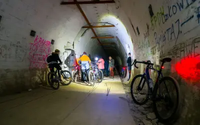 Grupa rowerzystów eksploruje mroczną, graffiti-pokrytą podziemną trasę rowerową.