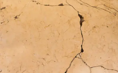 Surface de céramique beige fissurée, montrant comment réparer une céramique cassée.