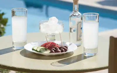 Ouzo, grecki alkohol, podawany z oliwkami i ogórkiem, przy basenie, jak na wakacjach pod Partenonem.