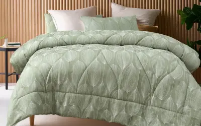 A sage green coverlet with a white leaf pattern. This coverlet serves as a decorative top layer for the bed, adding warmth and style.