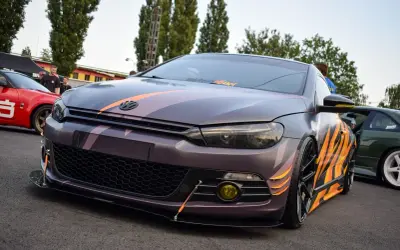 Zmodyfikowany Volkswagen Scirocco z nakładkami na błotniki w płomienie i pasy.