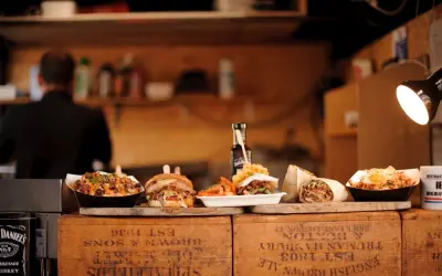 Kebab, burger, frytki i inne dania na drewnianych skrzynkach.