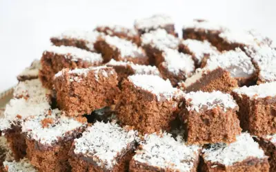 En hög med små, fyrkantiga chokladbitar, en klassisk snoddas kaka, toppade med kokosflingor.