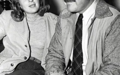 Ernest Hemingway i jego żona Mary Welsh siedzą blisko siebie, ona uśmiecha się lekko.
