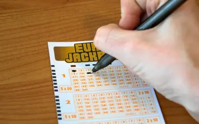 Ręka zaznacza liczby na kuponie Eurojackpot. Zastanawiasz się, dlaczego w Polsce nie można grać w Eurojackpot anonimowo przez pełnomocnika?