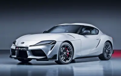 Biała Toyota Supra GR z czerwonymi zaciskami hamulcowymi. Ta sportowa marka samochodu na zdjęciu prezentuje dynamiczną sylwetkę.