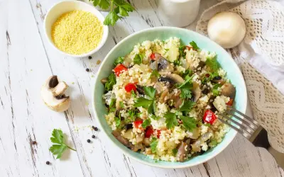 Un gustoso cous cous con funghi, peperoni e prezzemolo fresco. Un piatto leggero e saporito.