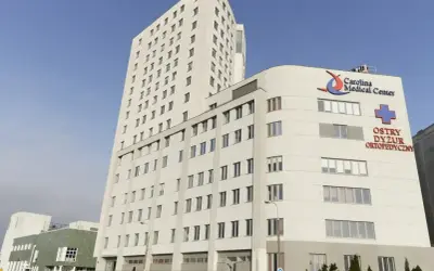 Nowoczesny budynek Carolina Medical Center w Warszawie z logo i napisem "Ostry Dyżur Ortopedyczny".