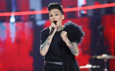 Agnieszka Chylińska śpiewa na scenie, przygotowując się do koncertów w 2026 roku. Jej charakterystyczny styl i tatuaże przyciągają wzrok.