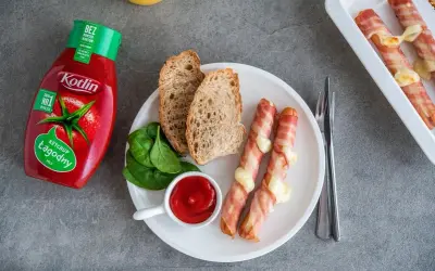 Parówki po kanadyjsku zawinięte w boczek z serem, podane z chlebem, szpinakiem i ketchupem Kotlin.