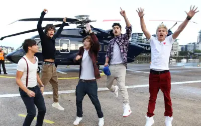 Chłopcy z One Direction skaczą z radości obok helikoptera, jakby właśnie usłyszeli swoje nowe piosenki.