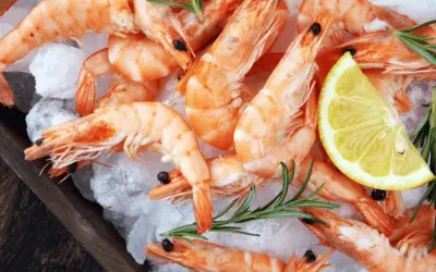 Świeże krewetki na lodzie z cytryną i rozmarynem. Idealne do przygotowania, gdy chcesz wiedzieć, jak obrać krewetki.