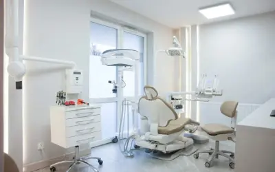 Nowoczesny gabinet stomatologiczny z fotelem dentystycznym i sprzętem medycznym.