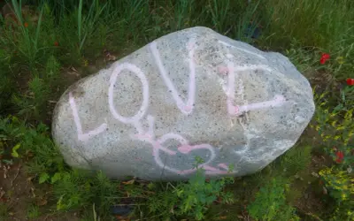Duży kamień z różowym napisem LOVE i sercem.