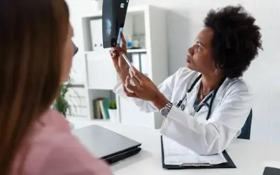 Lekarka omawia z pacjentką wynik mammografii, wskazując na zmiany. BIRADS 5 rokowania wymaga dalszej diagnostyki.