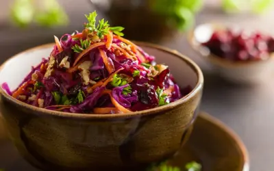 Wykwintna surówka z czerwonej kapusty jak w restauracji, z marchewką, orzechami i żurawiną, udekorowana natką pietruszki.