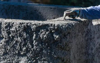 Ręka w rękawicy wygładza świeży beton B20. Sprawdzamy beton B20 cena za m3.