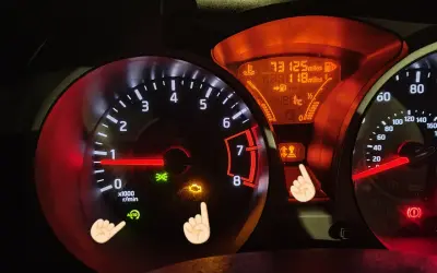 Kontrolki Nissan Juke: obrotomierz, prędkościomierz, wskaźnik paliwa i temperatury. Świecą się kontrolki silnika i hamulca.