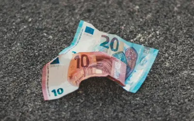 Uszkodzone banknoty 10 i 20 euro leżą na szarej powierzchni. Dowiedz się, gdzie wymienić uszkodzony banknot euro.